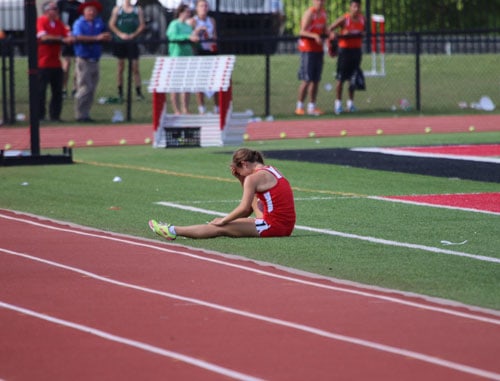 Lawrence sat in emotional and physical pain after she stepped off the track at the 5A State Teack Meet in the 3,200 meter run. Photo by Lisa Geissler.